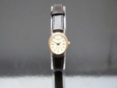Rotary Elite 9ct gold ladies wristwatch with gold hands and baton markers, champagne dial, oval case