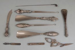 Five hallmarked silver handled button hooks and shoe horns, hallmarked silver novelty golf club
