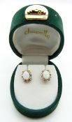 A pair of 9ct gold earrings set with opals and diamonds