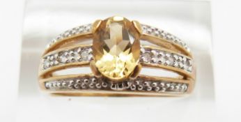 A 9ct gold ring set with an oval cut citrine and diamonds, 3.7g, size P