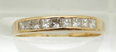 A yellow metal ring set with nine princess cut diamonds, 1.7g