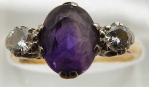 An 18ct gold ring set with an oval cut amethyst and two diamonds of approximately 0.2ct, 3g, size O