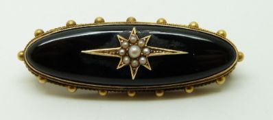 Victorian brooch set with onyx and seed pearls to the centre in a star setting