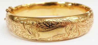 A 9ct gold bangle with engraved scrolling decoration, 14.5g (6.1 x 5.7cm)
