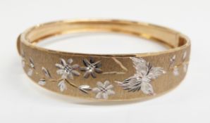 A 9ct gold bangle with foliate design, 9.69g, 5.7 x 5.3cm
