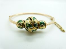 Yellow metal bangle with knotted section set with green and white enamel, 20.7g, 5.7 x 4.1cm