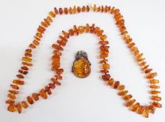 An amber necklace with angular pieces interspersed with cylindrical glass beads, 74g together with a