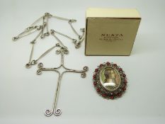 A white metal brooch set with a portrait miniature and a large silver cross and chain