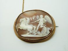 Victorian yellow metal brooch set with a cameo depicting a winged god being pulled by horses, 5.7