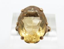 A 9ct gold ring set with an oval cut citrine in a scrolling setting, 5.9g, size M