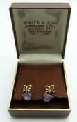 A pair of 9ct gold earrings set with a heart cut amethyst to each