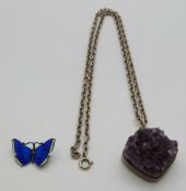 A silver necklace set with a section of amethyst by Bent K Denmark and a silver butterfly brooch set