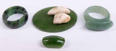 A nephrite jade plaque set with teeth and two jadeite rings