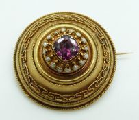 Victorian Etruscan Revival gold brooch set with a cushion cut garnet surrounded by seed pearls