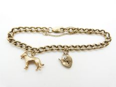 A 9ct gold curb link bracelet with a 9ct gold dog charm and heart padlock clasp, 19.4g