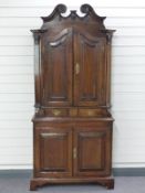 Antique oak double height cupboard, the top having arch top doors opening to reveal shaped