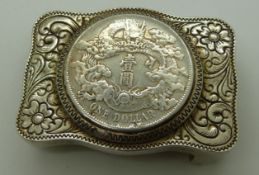 Chinese belt buckle in white metal floral and foliate design, coin to centre, pierced and signed