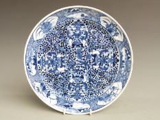 A 19thC Chinese blue and white plate with decoration of figures holding a large vase, four character