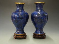 A pair of Japanese cloisonné vases on hardwood stands, 34cm tall