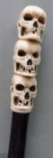 A walking stick with carved marine ivory handle depicting three skulls, 91cm long