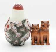 A Chinese glass overlaid scent bottle depicting a dragon and a boxwood netsuke depicting two cats,