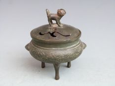 A bronze tripod censer / koro decorated with birds amongst bamboo friezes with Dog of Fo finial,