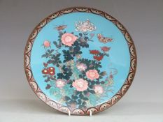 A 19thC Japanese cloisonné charger with butterfly and floral decoration, diameter 29.5cm