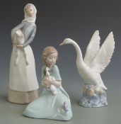 Lladro figurine girl with lamb and two Nao figures, tallest 27cm