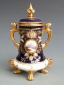 Coalport lidded vase, the four gilt pad feet leading to a tapered body hand decorated cartouche