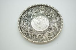 Chinese white metal pin dish with inset coin, further decorated with a dragon and a phoenix, 10cm