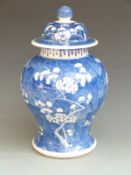 A 19thC Chinese covered pedestal ginger jar decorated with prunus blossom, four character underglaze