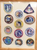 Twelve cloth Apollo space exploration badges or patches in glazed frame