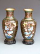 A pair of Japanese cloisonné vases on hardwood stands, 33cm tall