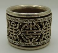 Chinese white metal thumb ring with rotating outer decorated ring, etched and pierced with symbols