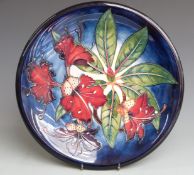 Moorcroft signed charger decorated with a variation of Hibiscus pattern dated 1999, boxed,