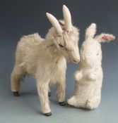 A fur covered metal goat with wooden horns, 48cm long together with a rabbit Teddy bear with white