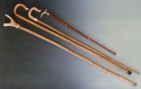 Four walking sticks one with glass reservoir, another with antler handle