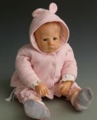 Wax or vinyl headed doll with closed mouth, fixed blue eyes, soft body and pink outfit, 57cm tall.