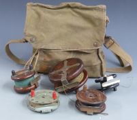 A collection of five vintage wooden and Bakelite fishing reels with a canvas bag