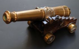 A bronze desk or signalling cannon with 7.5 inch graduated barrel, oak carriage and bronze wheels,