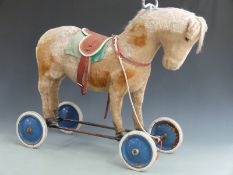 Steiff ride on horse on wheels with shaved spotted mohair, leather saddle, blue metal wheels and