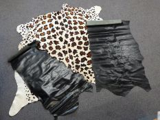 Three hides, one leopard approximately 180cm, two black leather finish approximately 190cm & 175cm