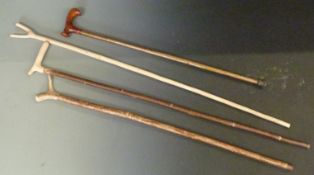 Four walking / shooting sticks with shaped tops and handles