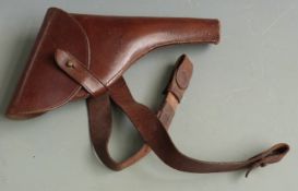 A brown leather revolver or pistol holster, 35cm long, on matching belt.