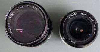 Two Nikon SLR camera lenses comprising Nikkor 135mm 1:3.5 and 28mm 1:3.5
