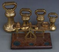 Four bell weights from 4lb downwards and a set of postal scales