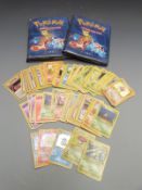 A collection of Pokemon cards including some rarer and shiny examples, some in folders.