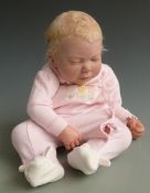 Jannie de Lange reborn doll with open mouth, closed eyes, pierced ears and pink babygro, 54cm tall.