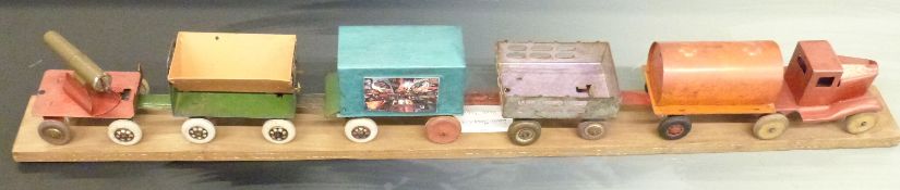 Louis Marx tinplate tanker lorry and four wagons / trailers mounted on a wooden plinth, 109cm long.