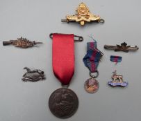 A collection of military badges and brooches to include silver sweetheart brooch for West